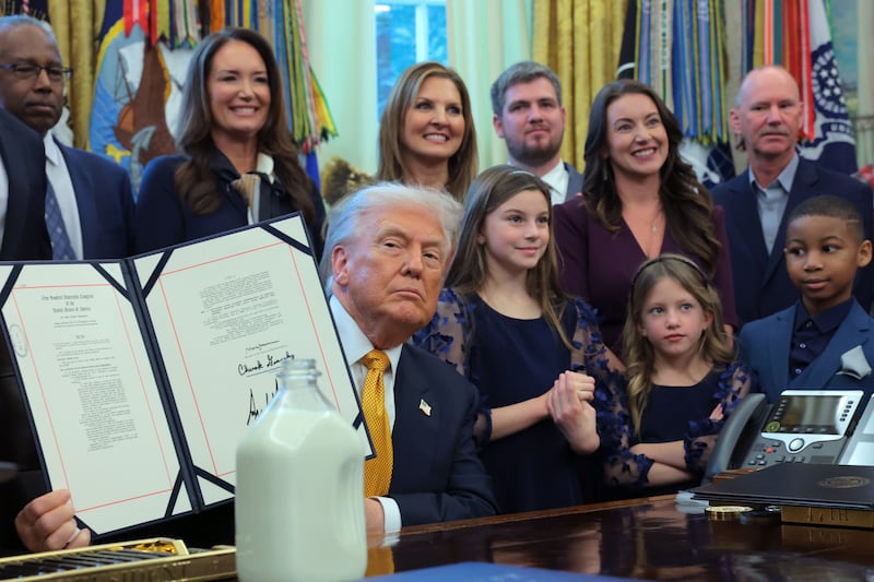 WASHINGTON, DC - JANUARY 14: U.S. President Donald Trump displays a signed bill during an event with dairy farmers in the Oval Office of the White House on January 14, 2026 in Washington, DC. Trump signed a series of bills including the "Whole Milk for Healthy Kids Act" to allow the sale of whole milk in school cafeterias across the country. (Photo by Anna Moneymaker/Getty Images)