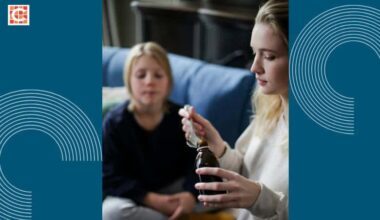 A mother gives her child medicine.