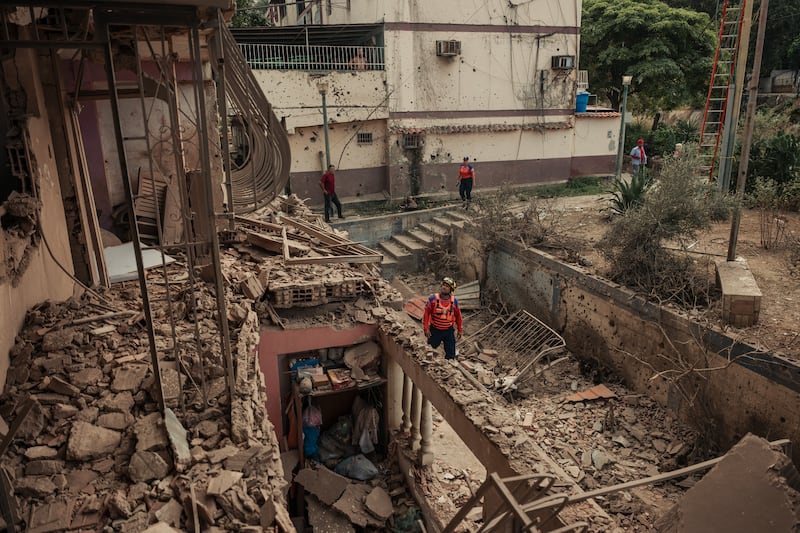 Civil defense workers and residents survey the damage to an apartment building in Catia La Mar, outside Caracas, on Saturday after the US military operation in which about 40 Venezuelans and 32 Cubans were killed. Photograph: The New York Times