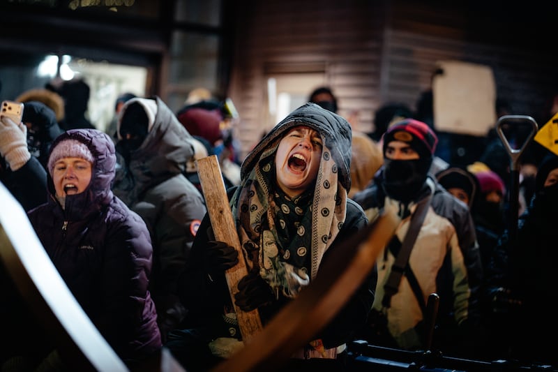 People pound on makeshift barriers, chant and yell at the site in Minneapolis where Alex Pretti was shot dead by federal immigration agents earlier that day, on Saturday, Jan. 24, 2026. (Jamie Kelter Davis/The New York Times)
                      