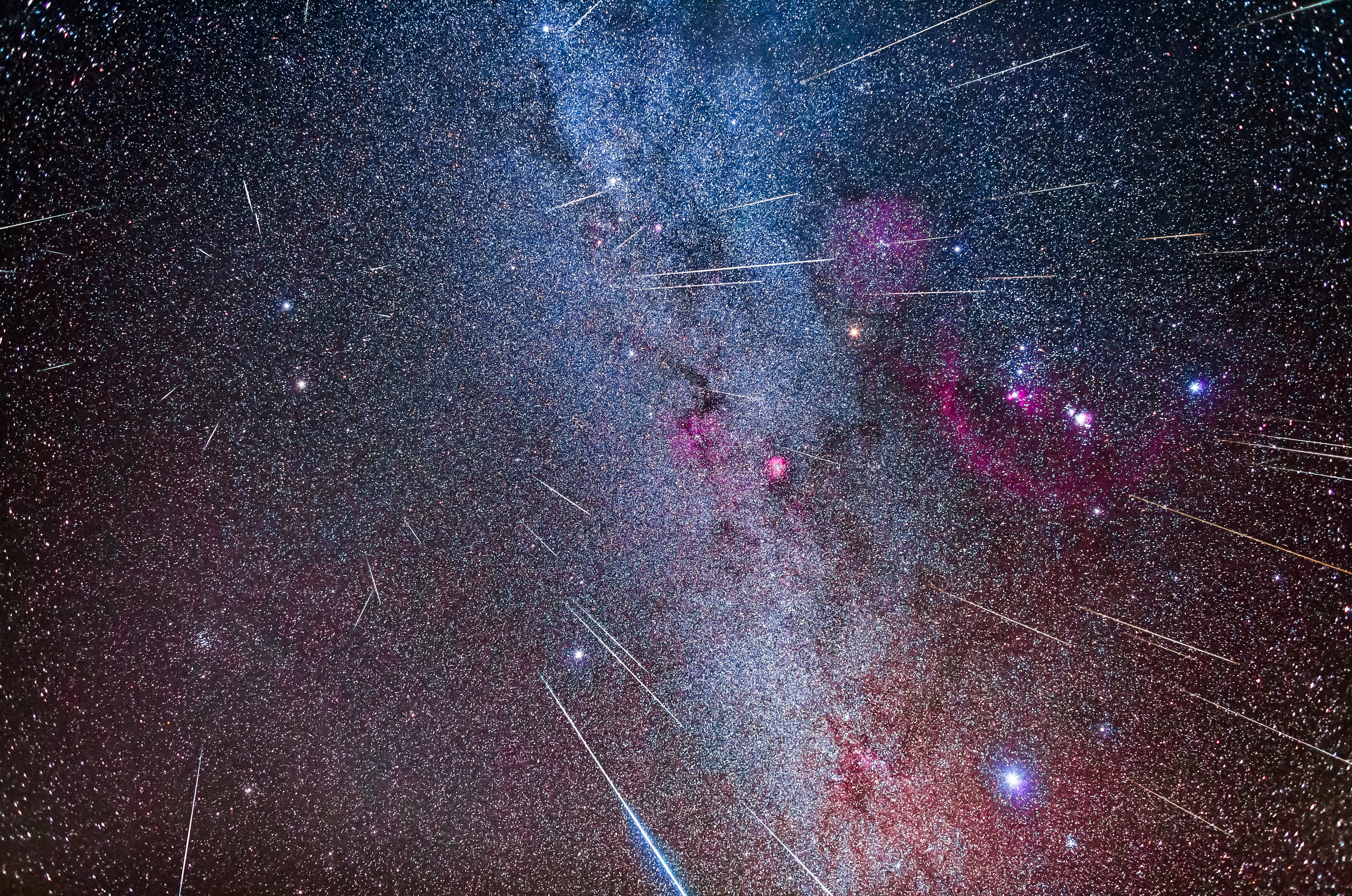 A composite showing the 2017 Geminid meteors streaking from the radiant point in Gemini at upper left, above the blue-white star Castor. 2 or 3 meteors are not Geminids as their paths do not project back to the radiant, but I have left them in regardless, as an illustration. This also illustrates how the meteor paths are shorter closer to the radiant and lengthen away from the radiant. Orion and its red nebulas are at right. The Beehive star cluster, M44, is at lower left. Sirius is the bright star at lower right. Taken December 13/14, 2017 during the very active 2017 Geminid meteor shower.