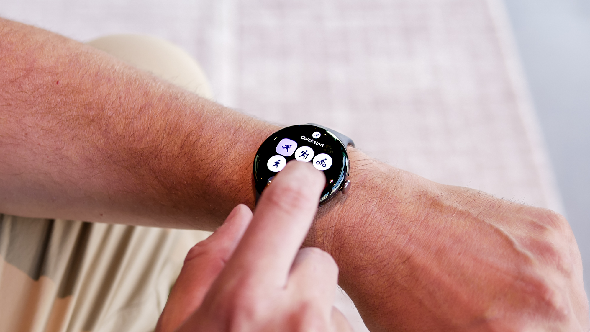Close-up of a user interacting with Google Pixel Watch 4 touchscreen