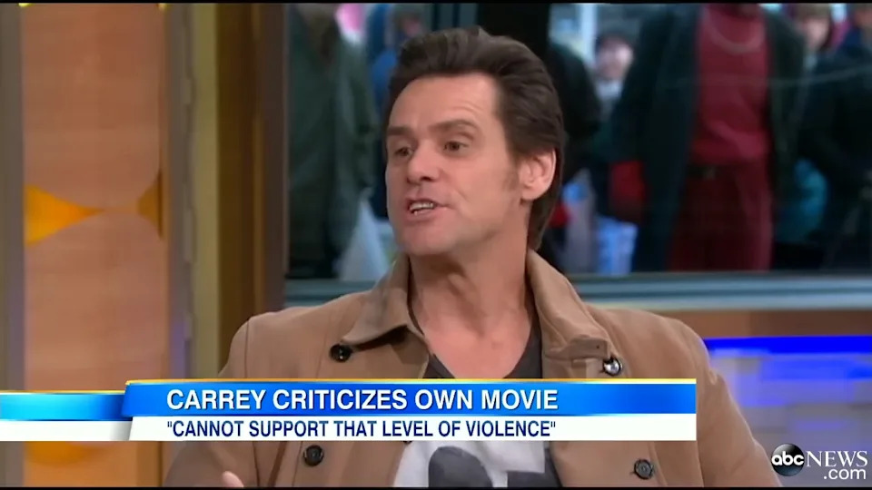 Person in a TV interview discussing criticism of their own movie due to violence concerns, with news banner headline displayed