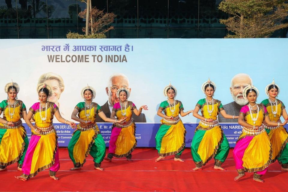 Dancers in front of a picture of European Commission president Ursula von der Leyen, European Council president Antonio Costa and India's prime minister Narendra Modi