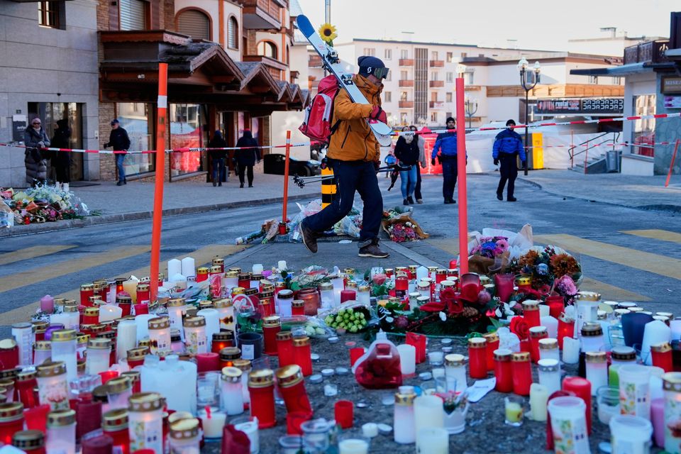 A skier passes candles near the sealed off Le Constellation bar. Photo: AP