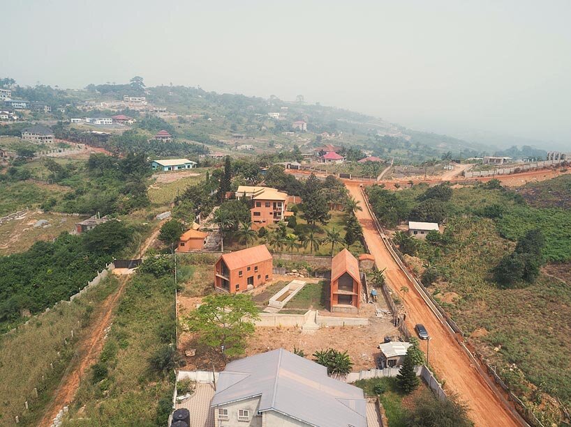 clay-pigmented monolithic villas emerge from ghana’s red earth landscape
