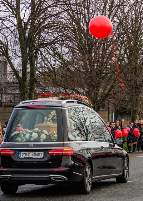 The funeral cortege of Grace Lynch passes St Michael's secondary school as students release ballons into the sky. Picture by Mark Condren