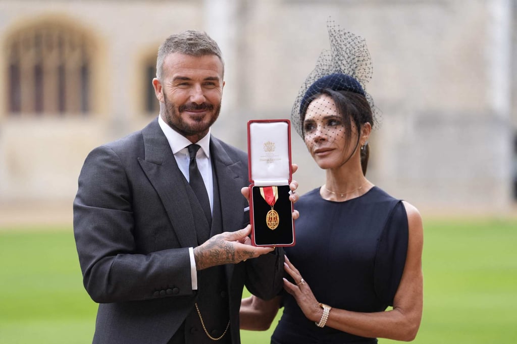 David Beckham, with his Knighthood medal, and Victoria Beckham. Photo: AFP