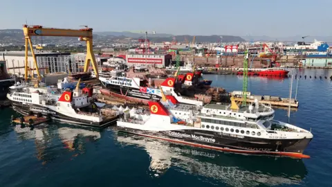 CMAL Four black and white ferries berthed at a shipyard