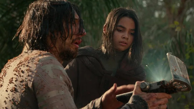 Adam Driver's Mills shows Ariana Greenblatt's Koa a device in 65