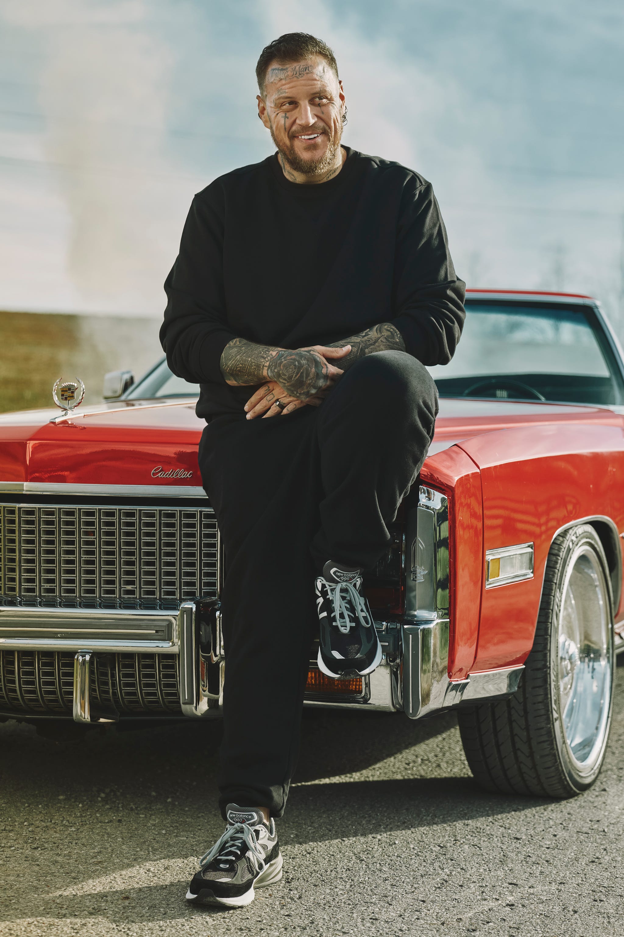 person sitting on a classic red cadillac