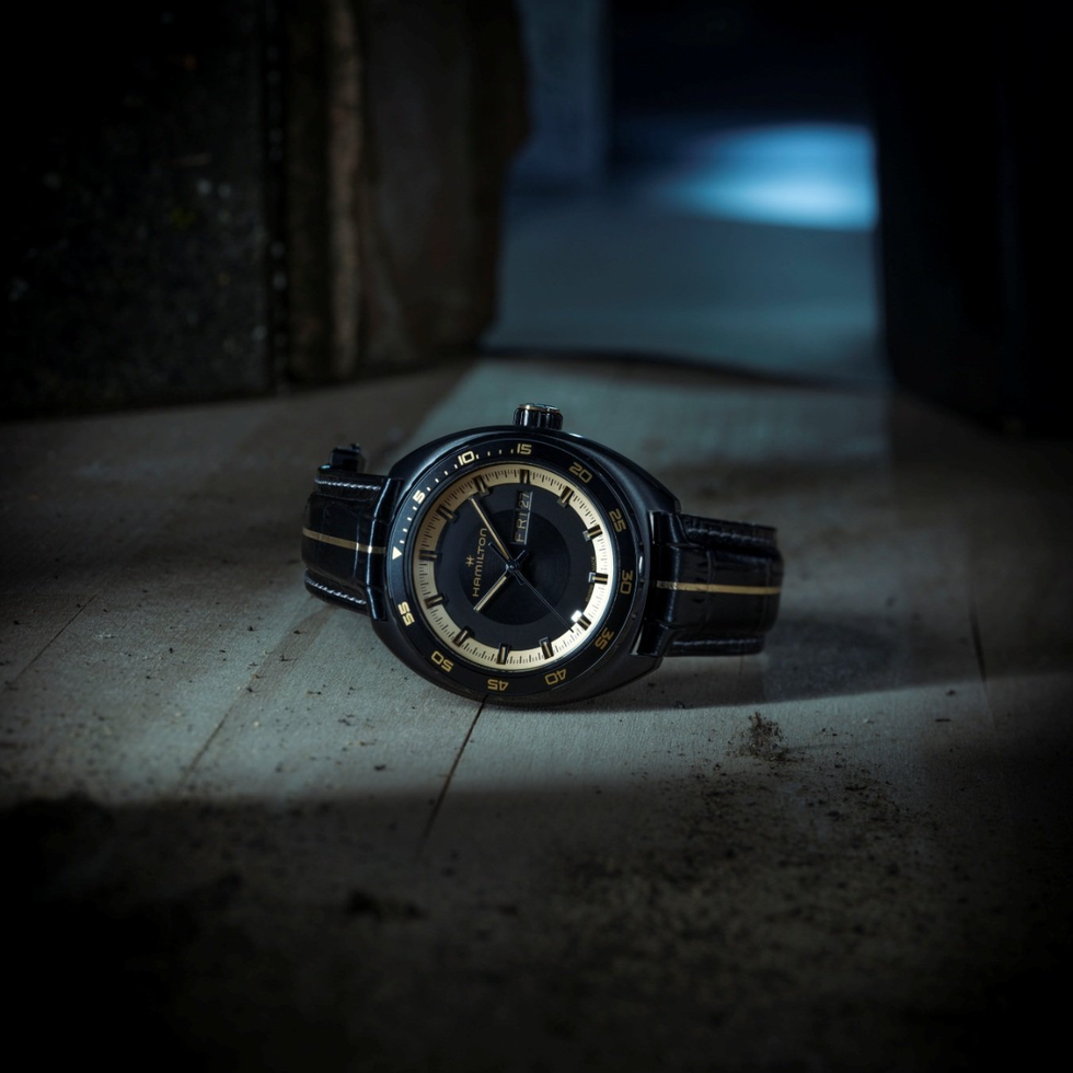 wristwatch on a wooden surface illuminated by soft light