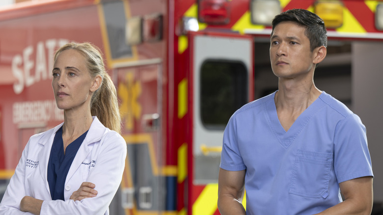 Teddy Altman and Benson Kwan stand in front of an emergency vehicle on "Grey's Anatomy" (2005-present)