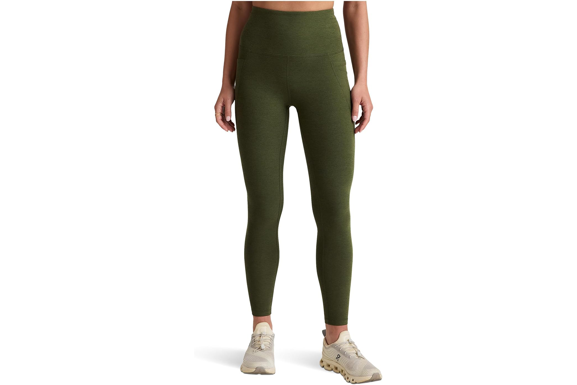 A person wearing olive green high-waisted leggings and light-colored sneakers.