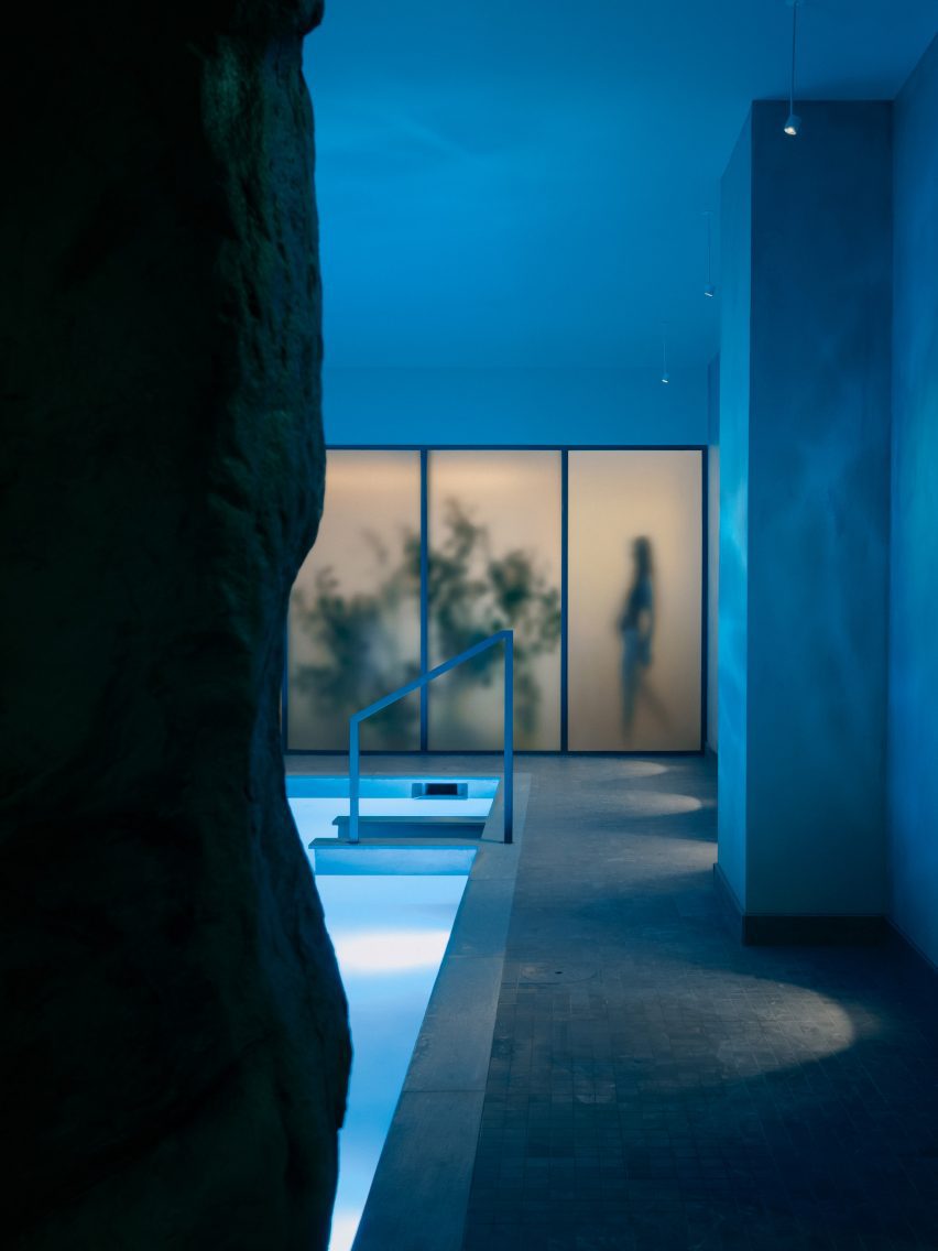 Frosted glass panels obscure the view from a plunge pool into a communal lounge area