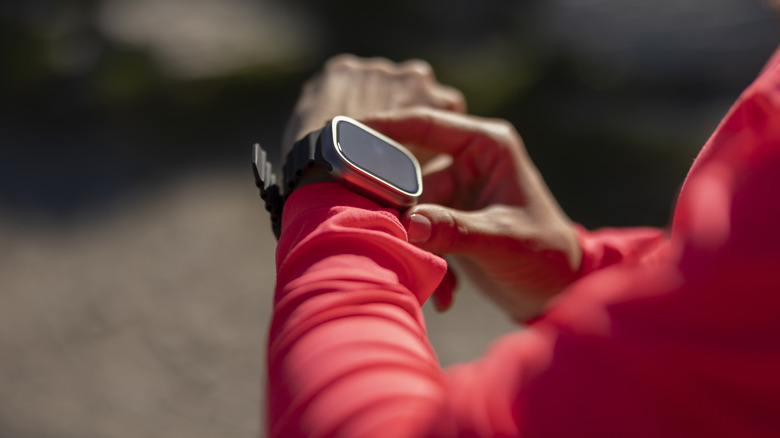 a woman touching her smartwatch