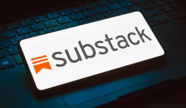 The Substack logo displayed on a phone that is resting on top of a keyboard