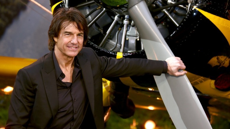 Tom Cruise leaning on a plane propeller