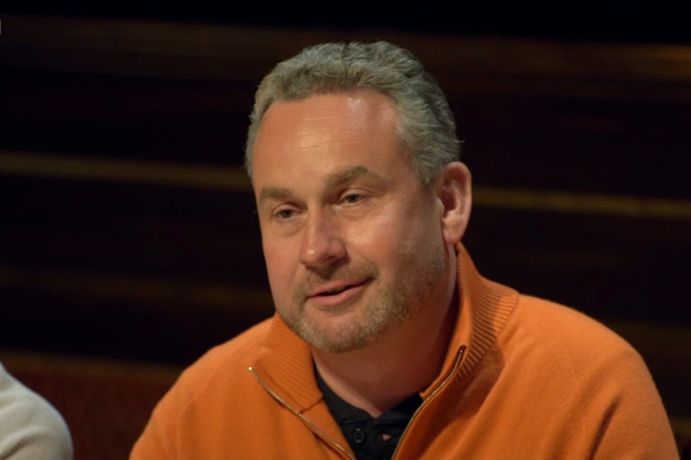 traitors season 4 hugo man in an orange sweater engaged in a discussion