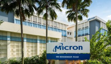 Micron Technology logo in front of palm trees and a large office building.
