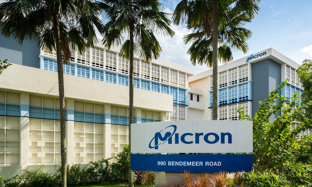 Micron Technology logo in front of palm trees and a large office building.