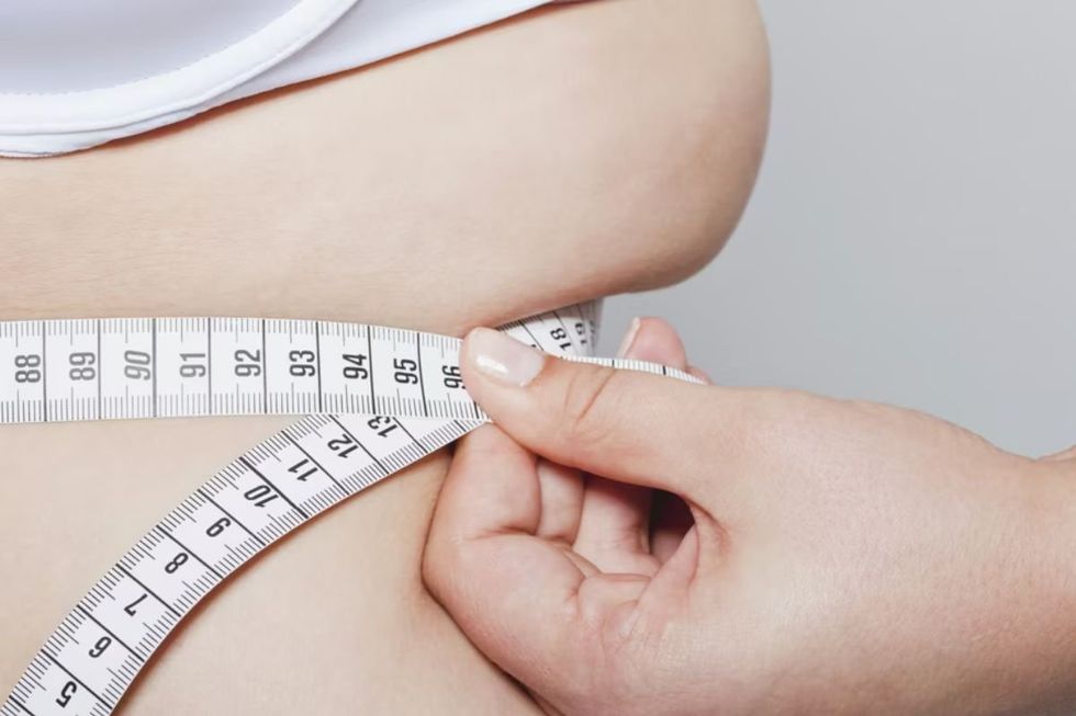 WOMAN TAKING WAIST MEASUREMENT