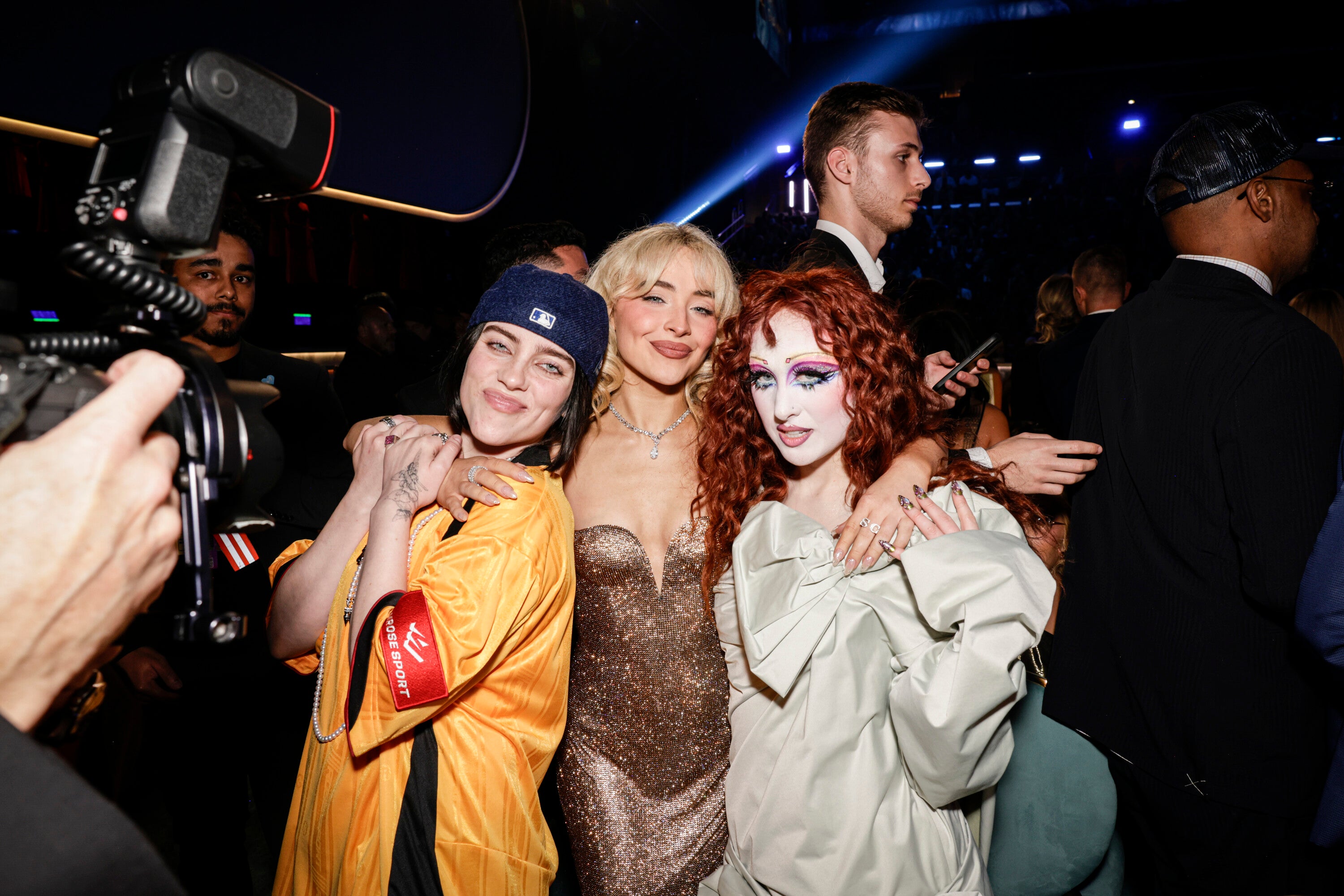 Billie Eilish, Sabrina Carpenter, and Chappell Roan hug during the grammys 2025
