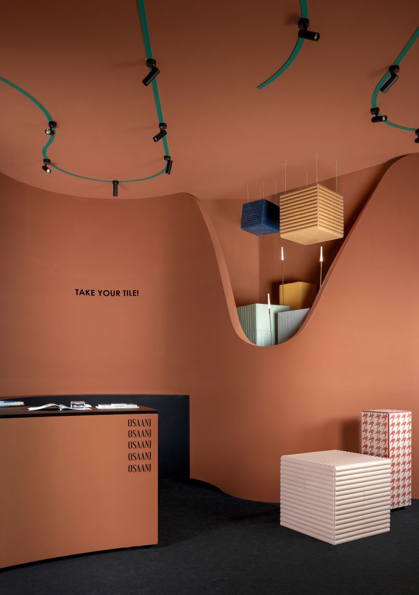 patterned tiles extend from curved walls to furniture in layered retail exhibition booth