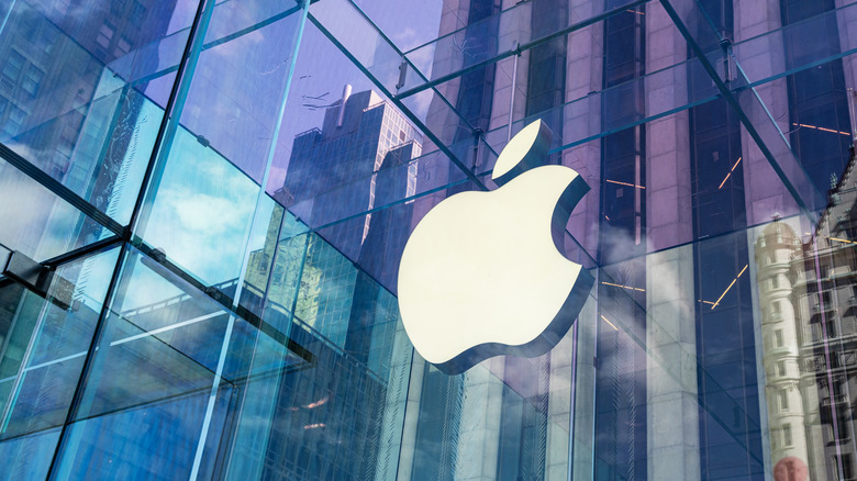 Apple logo on a glass building reflecting the city
