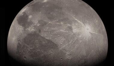 Ice volcanoes on Ganymede: Cratered, moon-like dark and light gray sphere with one large, bright white crater with rays.