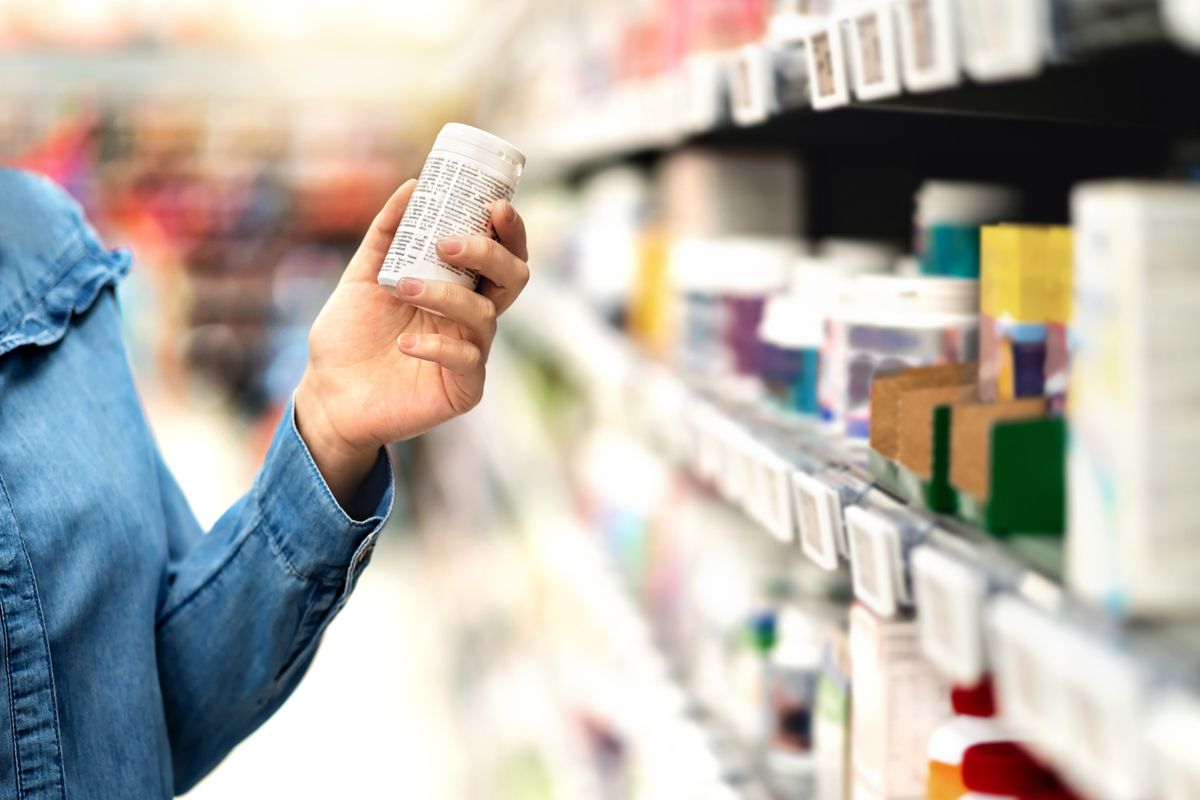 Customer in pharmacy holding medicine bottle