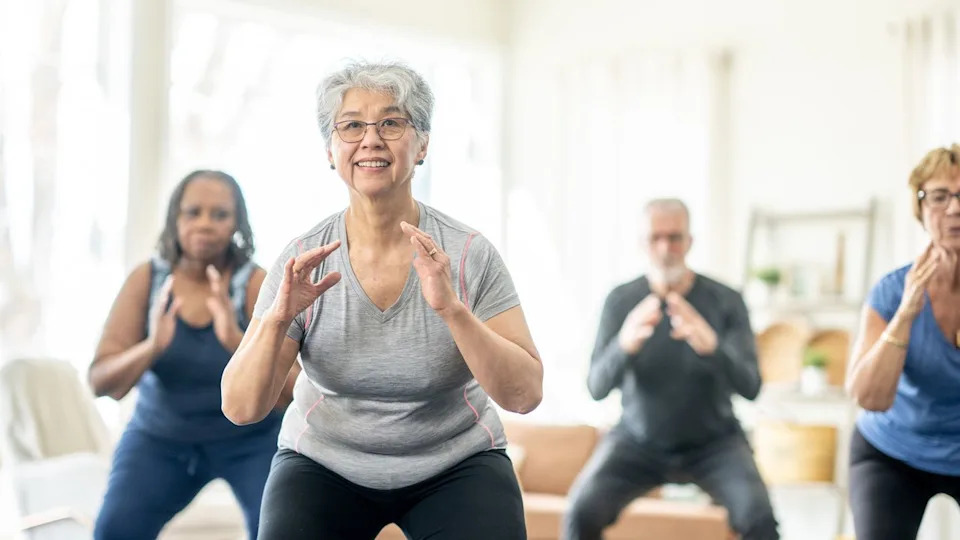 Group of four seniors exercising in domestic setting.