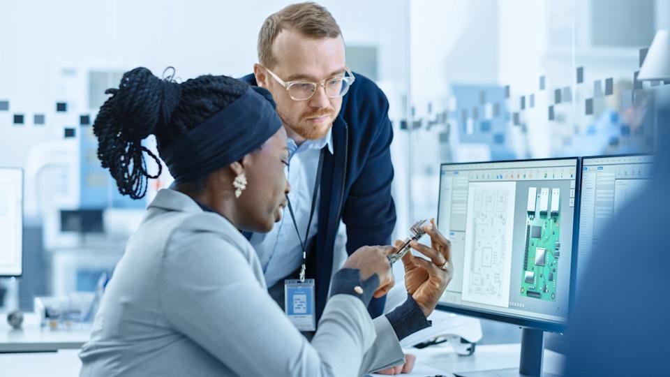 Two engineers designing chip architectures in a lab.