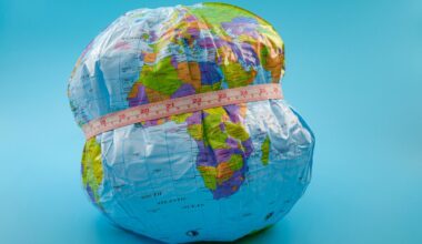 globe with measuring tape wrapped around it. Isolated on blue background.