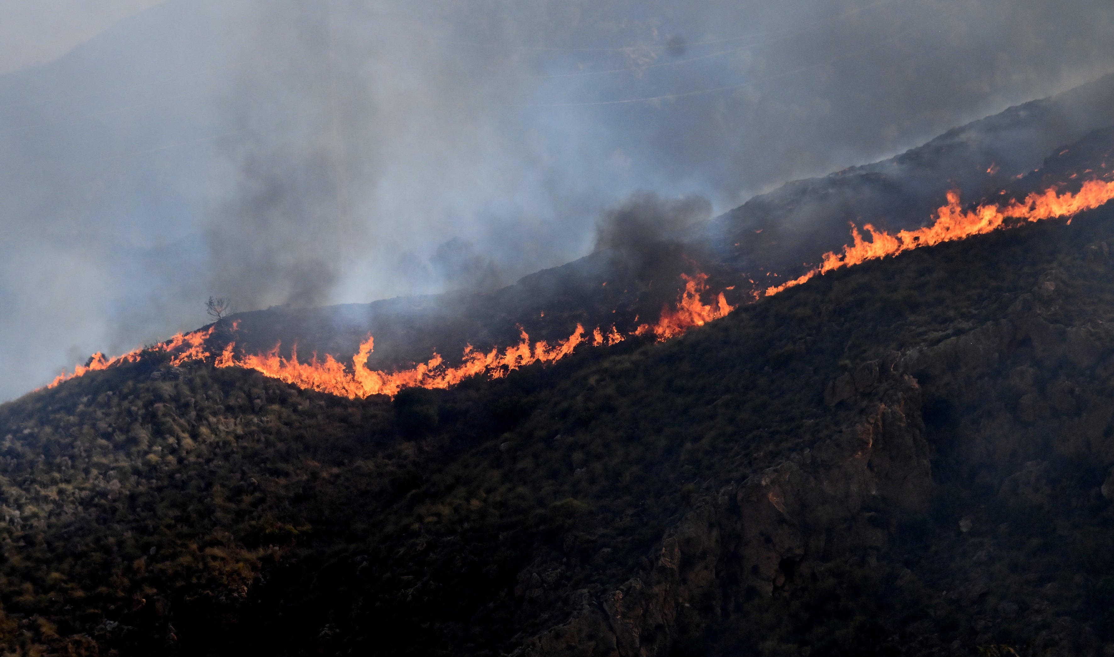 Flames burn on a hillside during a wildfire near Bédar on 10 July