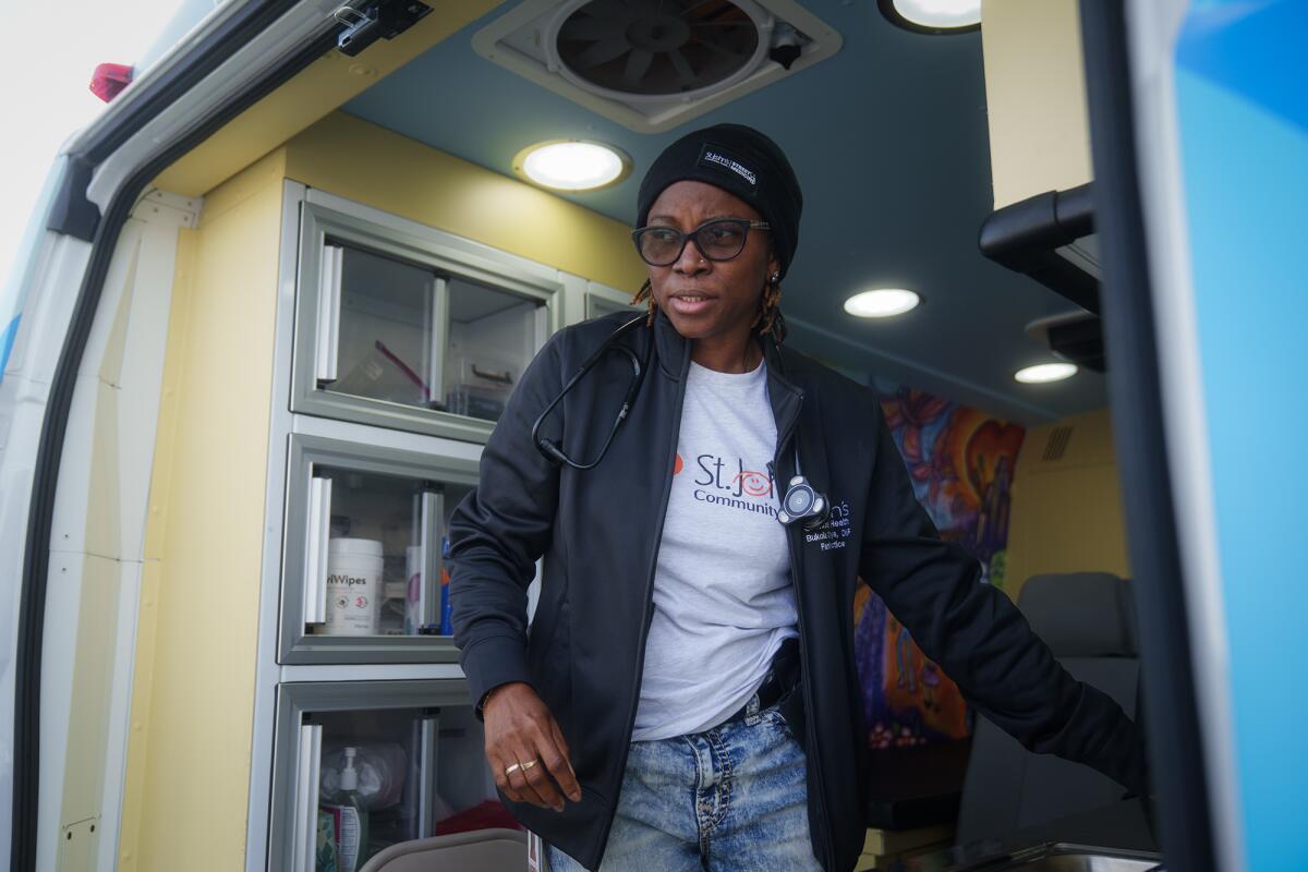 A woman steps out of a health clinic van