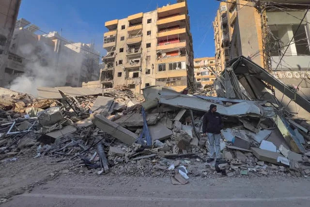 A man stands on the rubble of a destroyed building that was hit by an Israeli air strike in Dahiyeh, Beirut’s southern suburbs, Lebanon