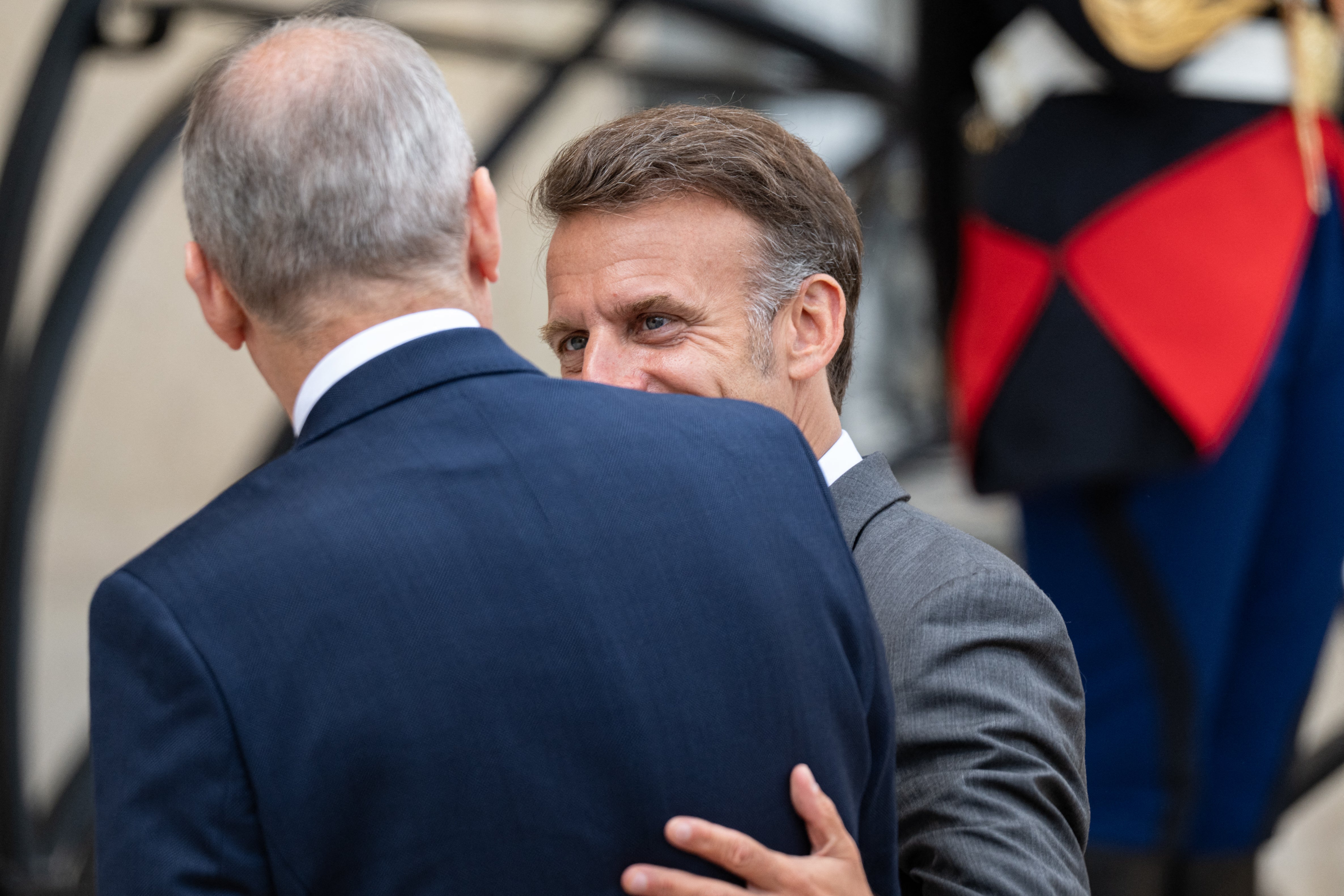 Micheal Martin (L), Prime Minister of Ireland, seen from behind, is welcomed by Emmanuel Macron (R),