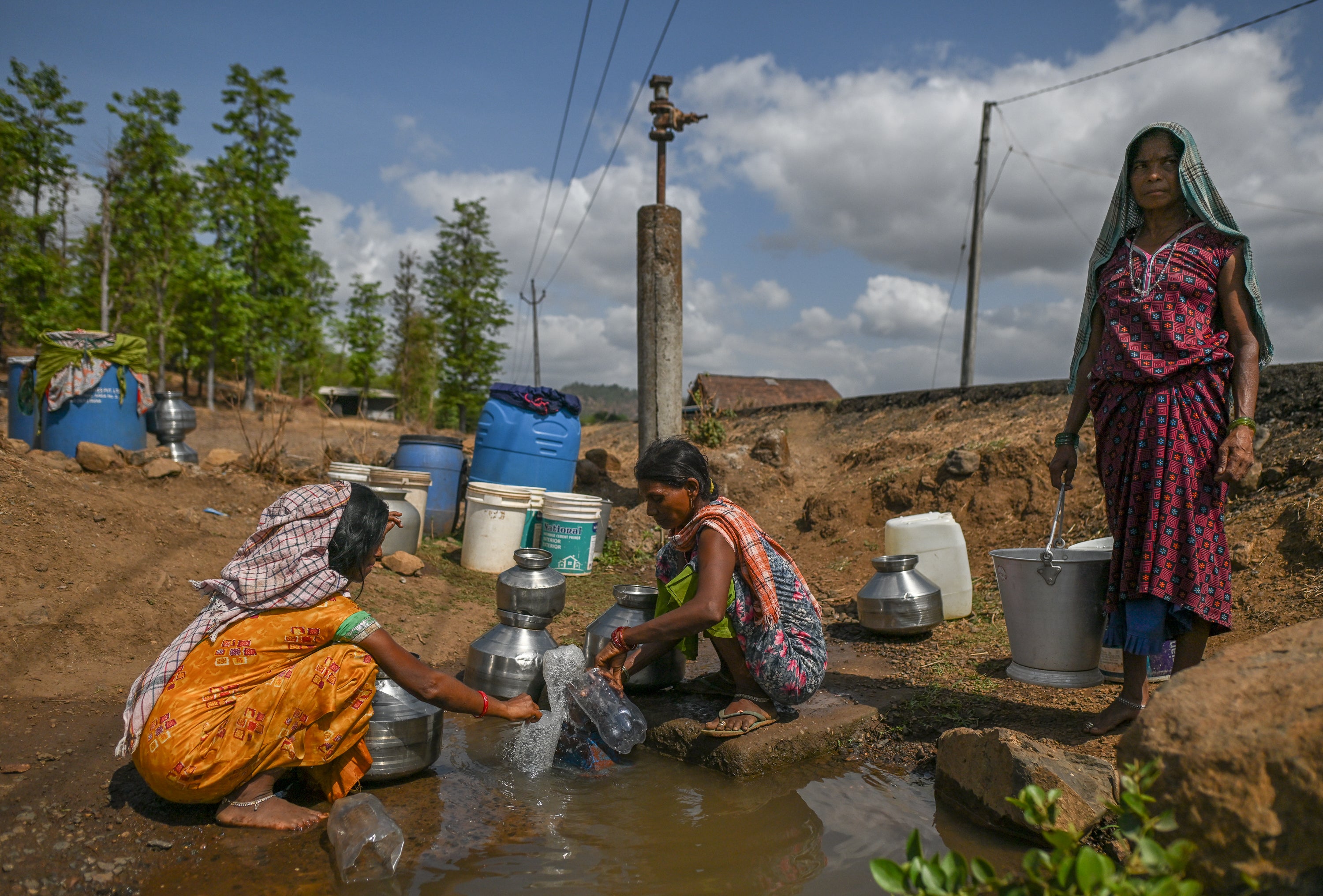Women collect water from a stagnant and polluted source in a drought affected village in Kaprada, Gujarat, on 27 May 2026