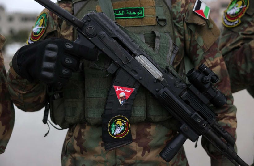 A Hamas fighter carries a rifle in the Gaza Strip, last year. Hamas is reportedly prepared to hand over not only weapons tied to internal security, but the broader machinery of governance to the National Committee for the Administration of Gaza, the writer says.