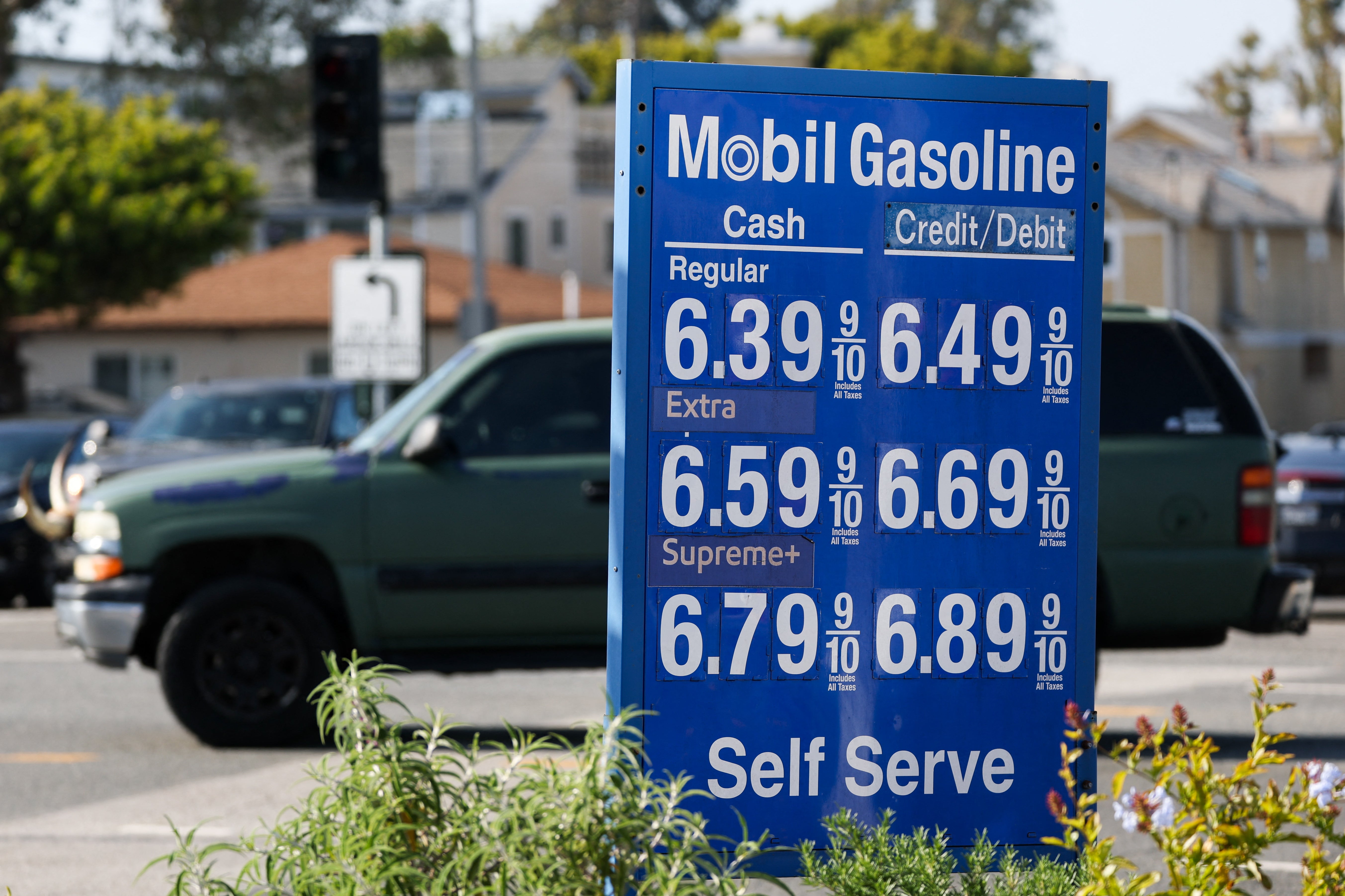 A vehicle drives past a Mobil gas station in Redondo Beach, California on April 30, 2026 where prices listed show over $6 per gallon