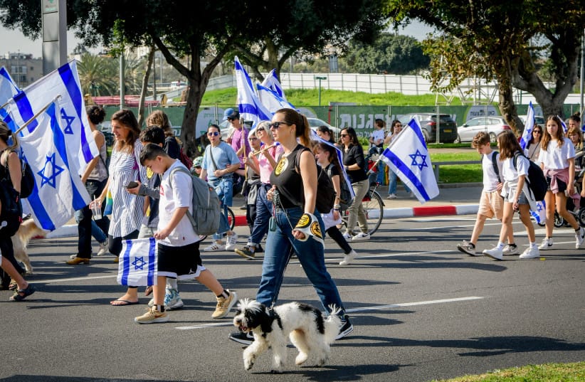 A woman is seen walking her dog amid the judicial reform protests in Tel Aviv, March 1, 2023.