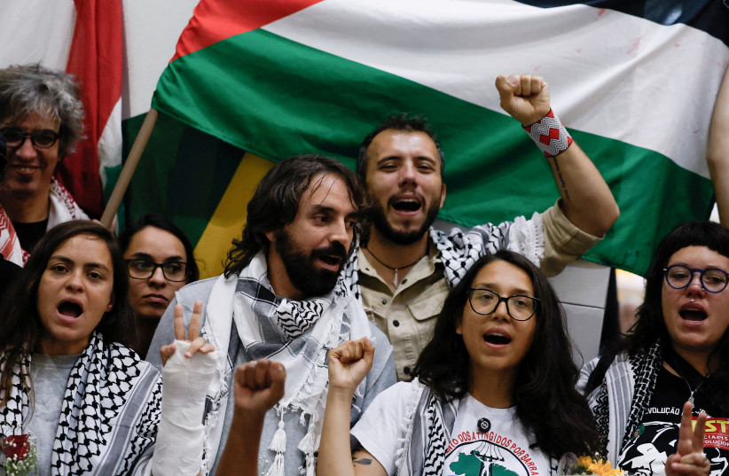 Brazilian activists who were detained aboard the Gaza-bound Global Sumud Flotilla, which was intercepted by Israeli forces, stand together as they arrive, with Brazilian activist Thiago Avila making a fist as he stands behind them, at Sao Paulo/Guarulhos International Airport after being deported.