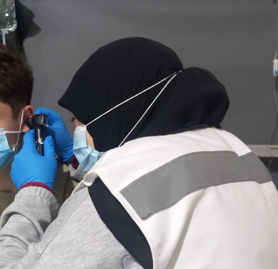 Israa checking a child's temperature