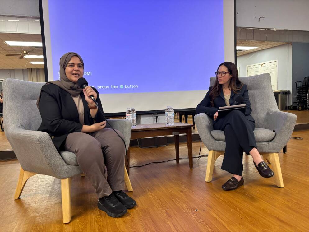 Two women sitting in chairs and having a conversation.