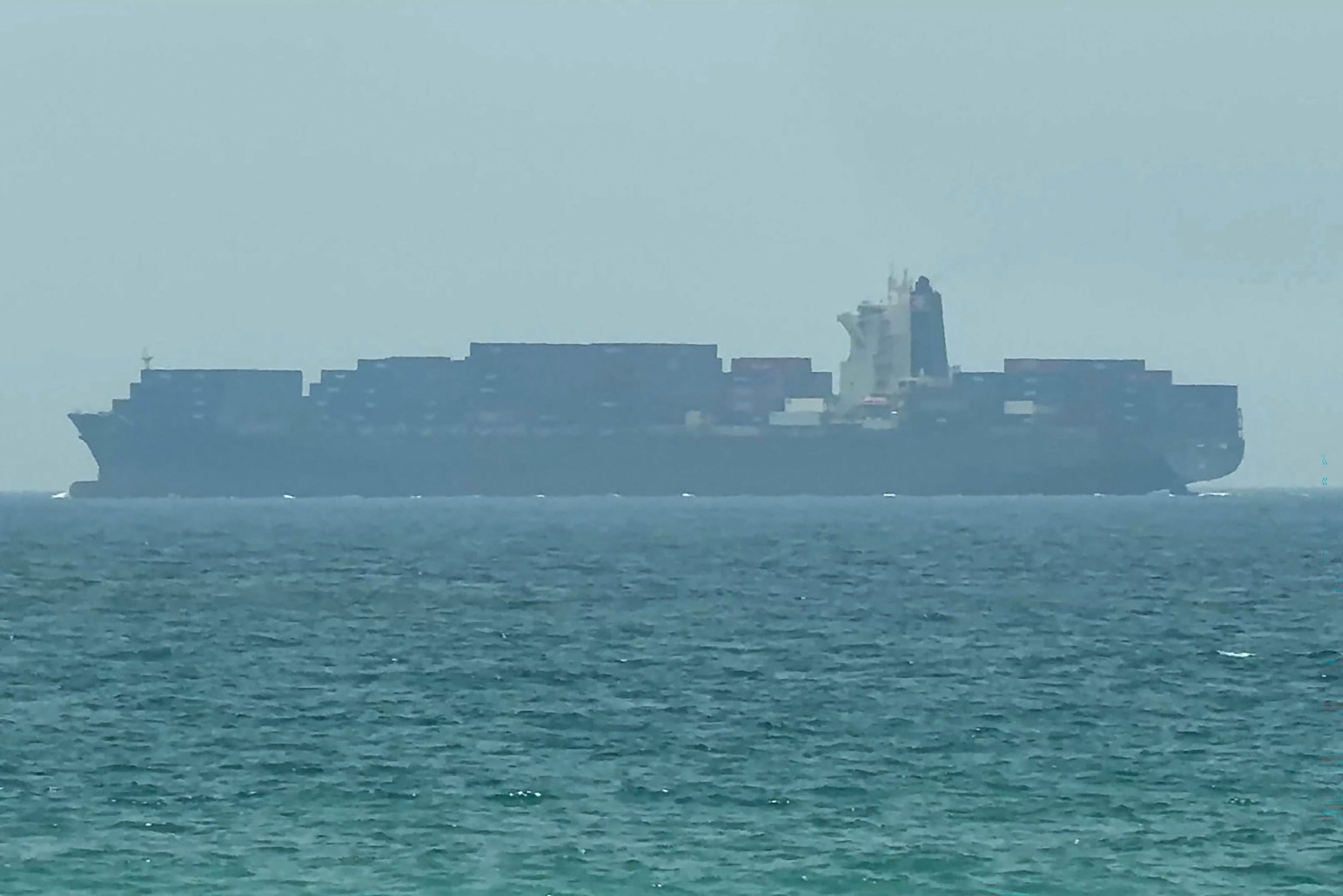 This frame grab taken from AFPTV video footage on July 12, 2026 shows a cargo ship anchoring near the Strait of Hormuz off the eastern coast of the United Arab Emirates at Khor Fakkan