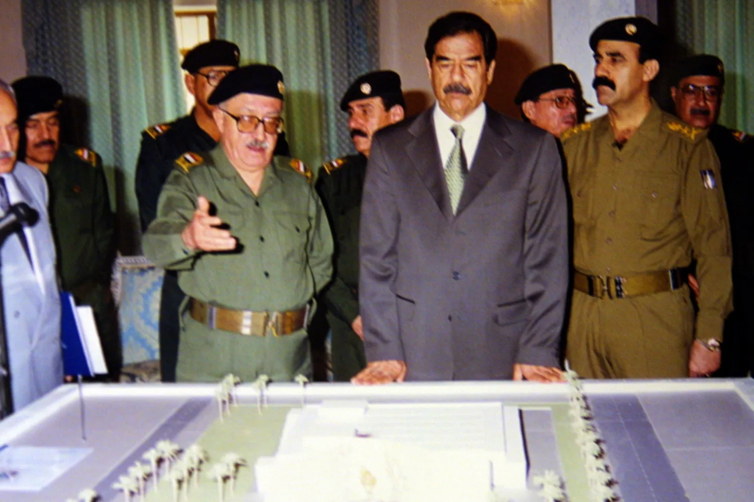 393984 01: Iraqi president Saddam Hussein (2nd R) listens to Deputy Prime Minister Tariq Aziz as they look at a model of the al -Amiria shelter September 3, 2001 in Baghdad. The shelter was hit by two air-to-surface missiles during the 1991 Gulf war, and more than 400 of its occupants were killed.