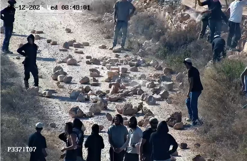 Settlers near Kusra blocking a road with rocks.