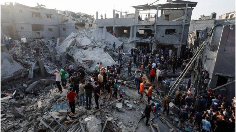 A large crowd gathers among the rubble of heavily damaged buildings following an attack, with rescue efforts underway at the scene (Photo: Reuters)
