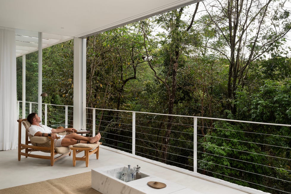 a modern esta casa iba a ser cobertizo y acabo convertido en el loft suspendido a la altura de los arboles de un arquitecto outdoor lounging space surrounded by greenery